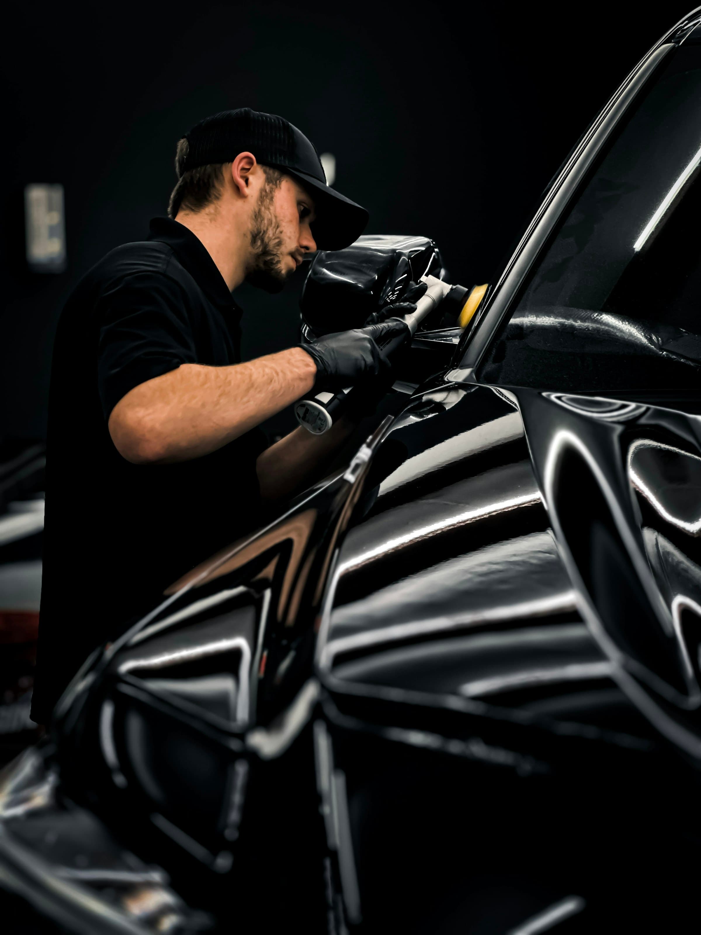 Detailer polishing a black luxury car